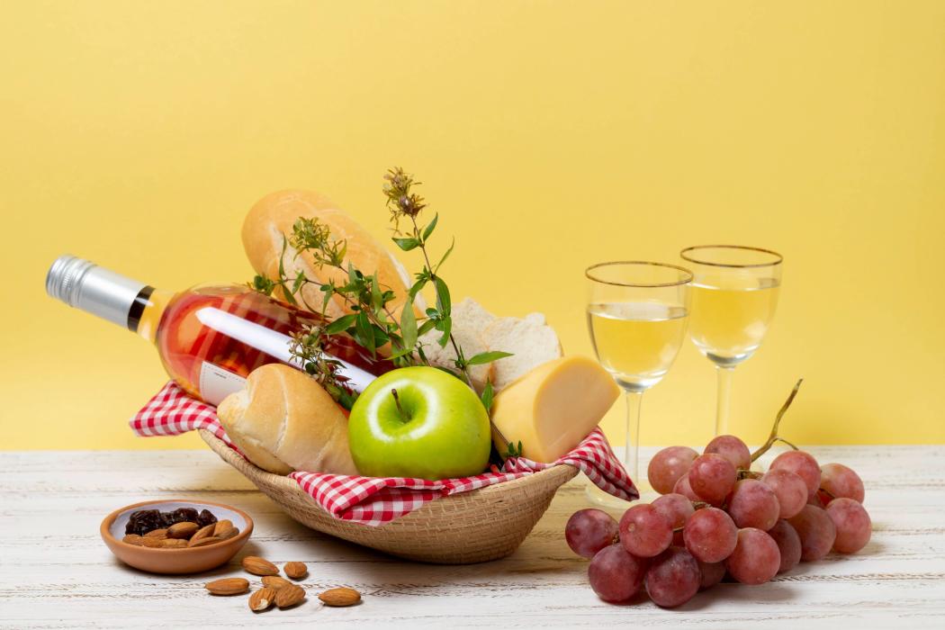 Panier garnis avec bouteille de vin, fruits et fromages
